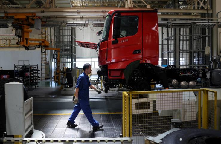 An employee walks at the truck assembly line at Beiben Trucks Group factory.