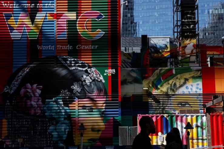 People walk in silhouette near the World Trade Center site in New York City, US.