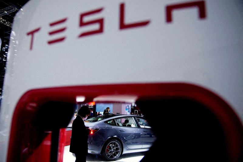 A Tesla electric vehicle is seen through a charging point displayed during a media day for the Auto Shanghai show in Shanghai, China 