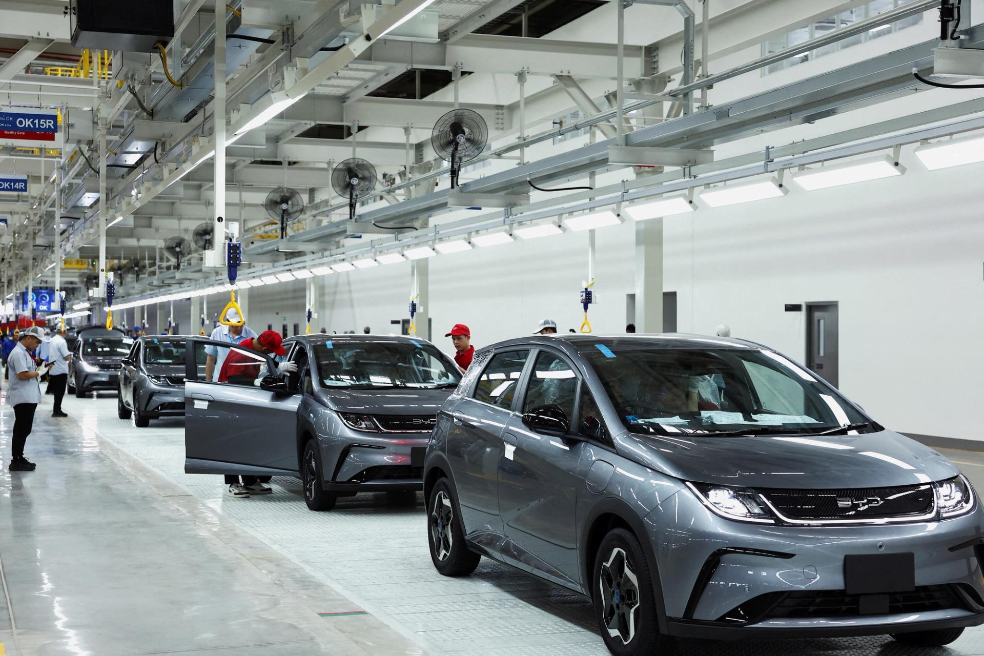 Workers check the EV cars inside BYD’s first electric vehicle factory in Southeast Asia