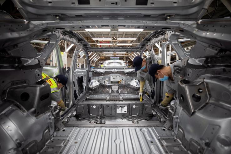 Employees work on an electric vehicle (EV) production line at a Volkswagen Anhui factory in Hefei.