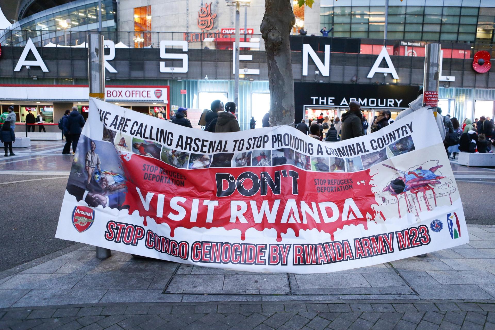 Protesters hold a banner saying “Don’t Visit Rwanda” outside Arsenal’s stadium.