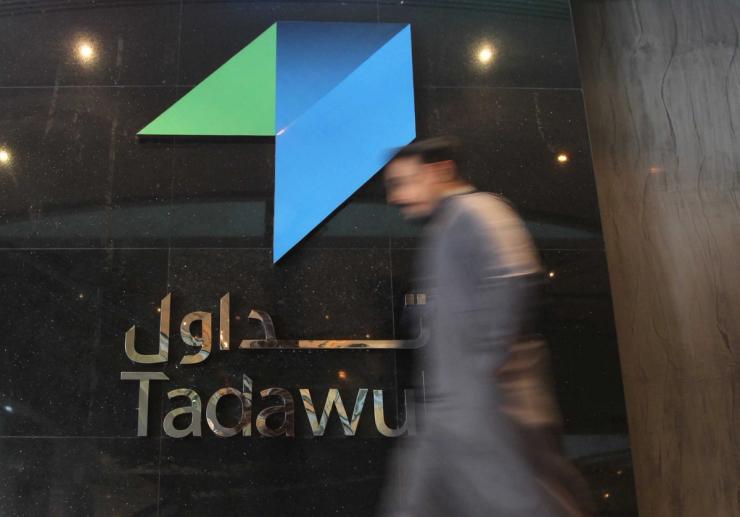 An investor walks at the Saudi Stock Exchange.