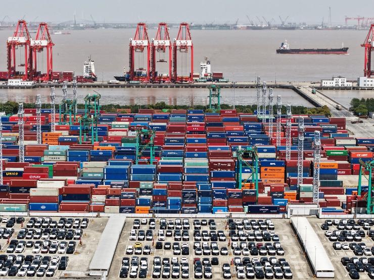 Drone view shows electric vehicles (EV) for export and containers sitting at a port in Shanghai.