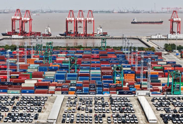 Drone view shows electric vehicles (EV) for export and containers sitting at a port in Shanghai.