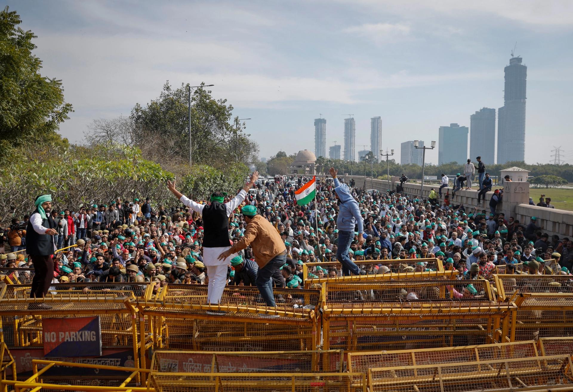 Farmers climb a police barricade during a protest demanding a hike in land compensation and better rehabilitation facilities for their families, in Noida on the outskirts of New Delhi, India, February 8, 2024. REUTERS/Adnan Abidi