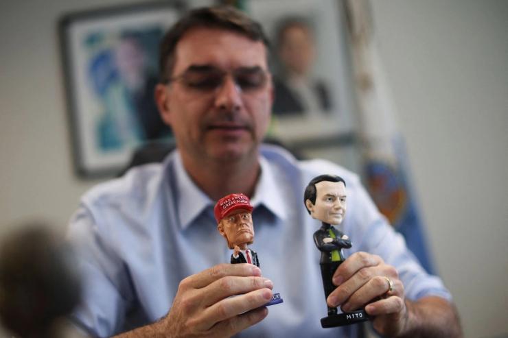 Flavio Bolsonaro holding dolls depicting his father and US President Donald Trump.