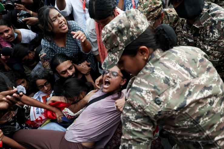 Protesters react as they are detained by security personnel during a protest seeking the resignation of India’s Chief Election Commissioner Gyanesh Kumar