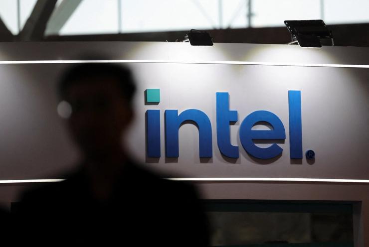 A man walks across the logo of Intel.