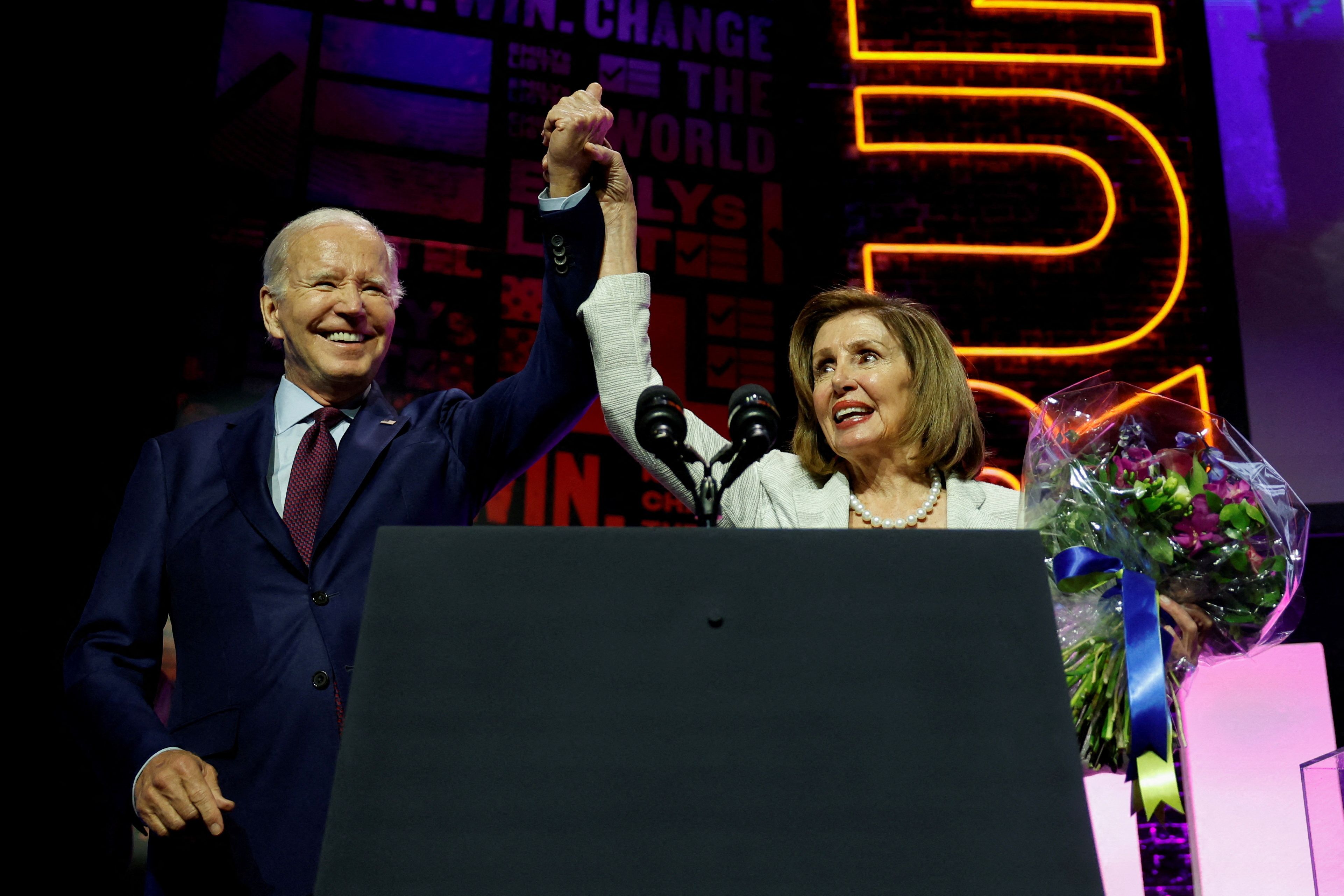 President Joe Biden and U.S. House of Representatives Speaker Emerita Nancy Pelosi hold hands at the 2023 EMILYs List Gala on May 16, 2023.