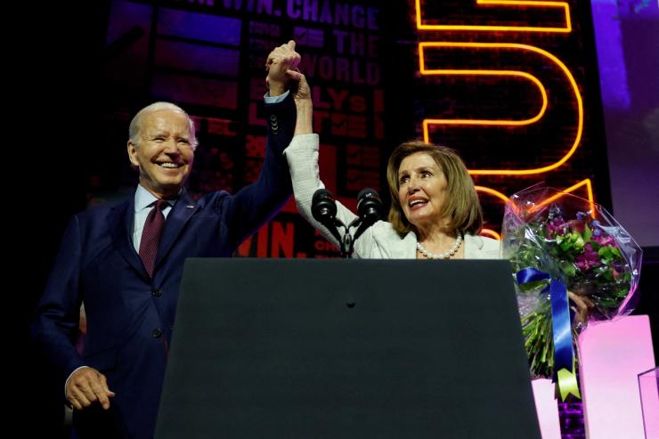 President Joe Biden and U.S. House of Representatives Speaker Emerita Nancy Pelosi hold hands at the 2023 EMILYs List Gala on May 16, 2023.