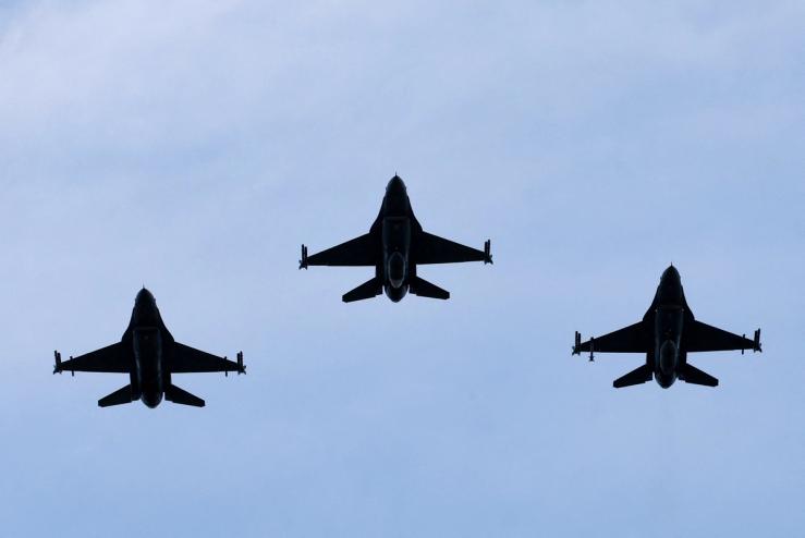 Belgian F-16 jets fly during a ceremony.