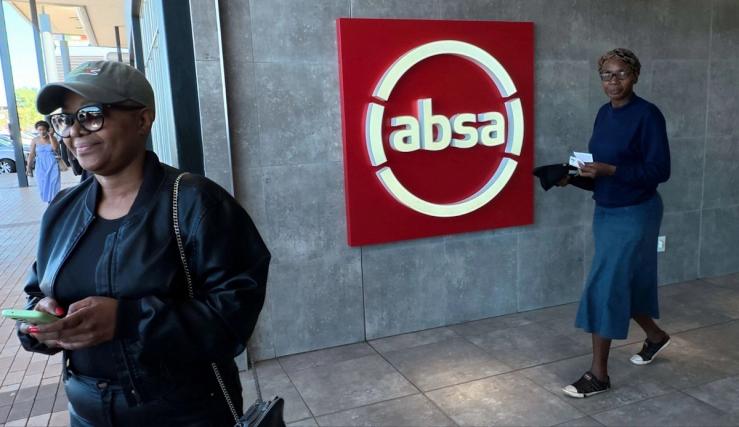 Shoppers walk past a logo of South African retail bank Absa in Soweto on April 10, 2025.