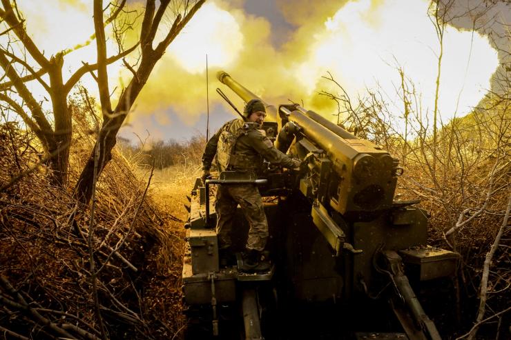 Ukrainian troops fire a self-propelled howitzer towards Russian troops at a front line