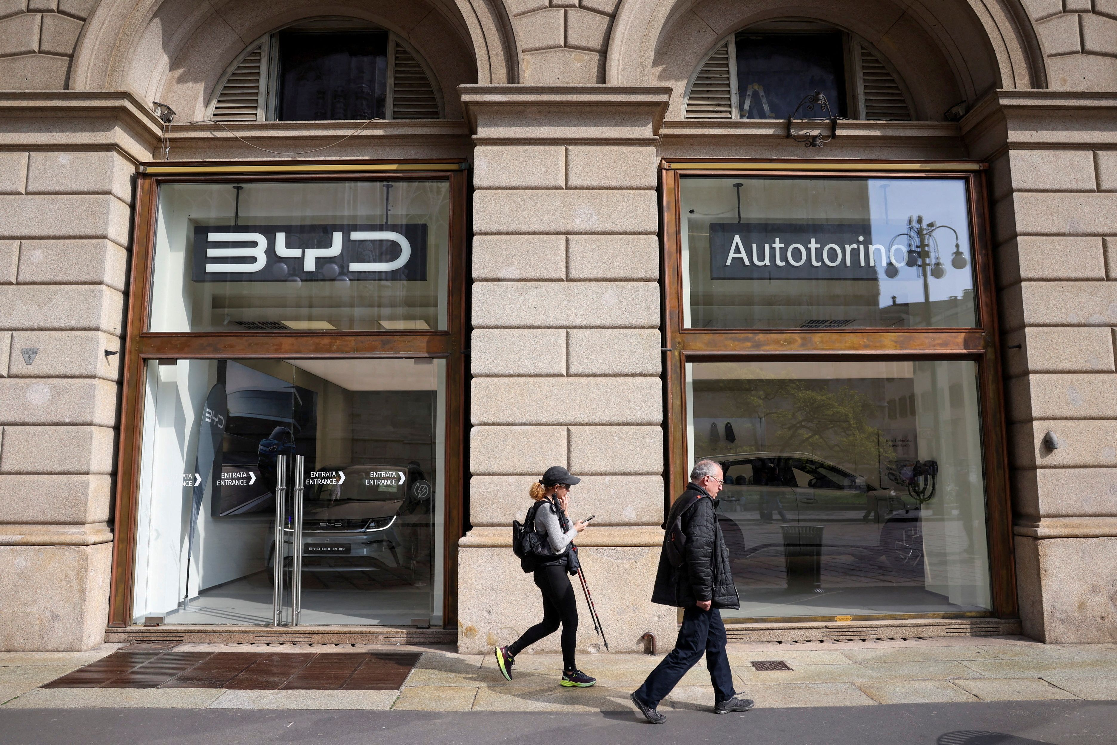 FILE PHOTO: People walk in front of BYD Auto company and Autotorino store in Milan, Italy, March 20, 2024. REUTERS/Claudia Greco/File Photo