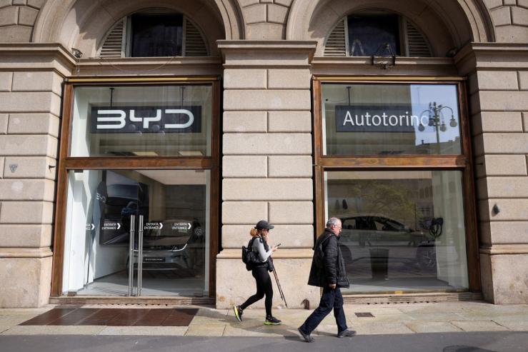 FILE PHOTO: People walk in front of BYD Auto company and Autotorino store in Milan, Italy, March 20, 2024. REUTERS/Claudia Greco/File Photo