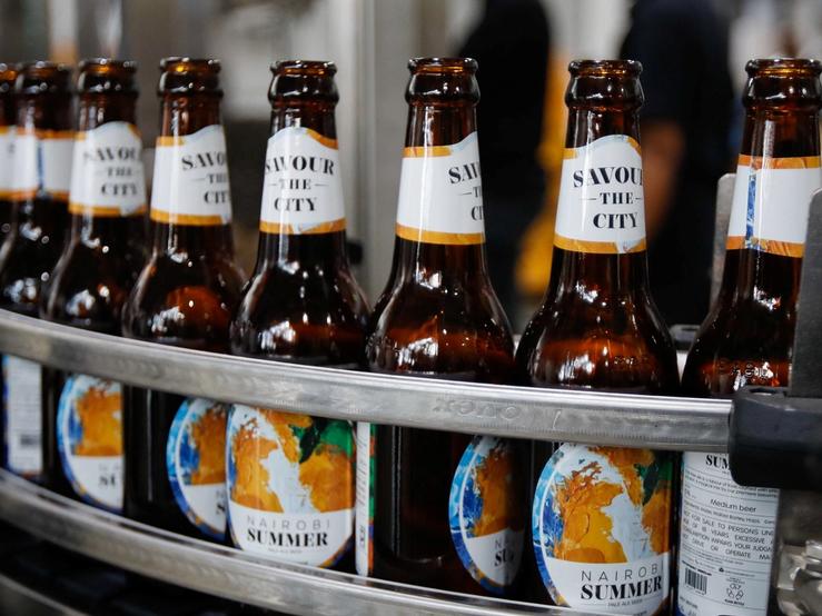Beer bottles pass through a conveyor belt along a production line at the East African Breweries’ microbrewery.