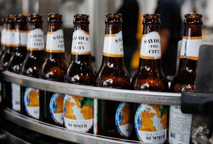 Beer bottles pass through a conveyor belt along a production line at the East African Breweries’ microbrewery.
