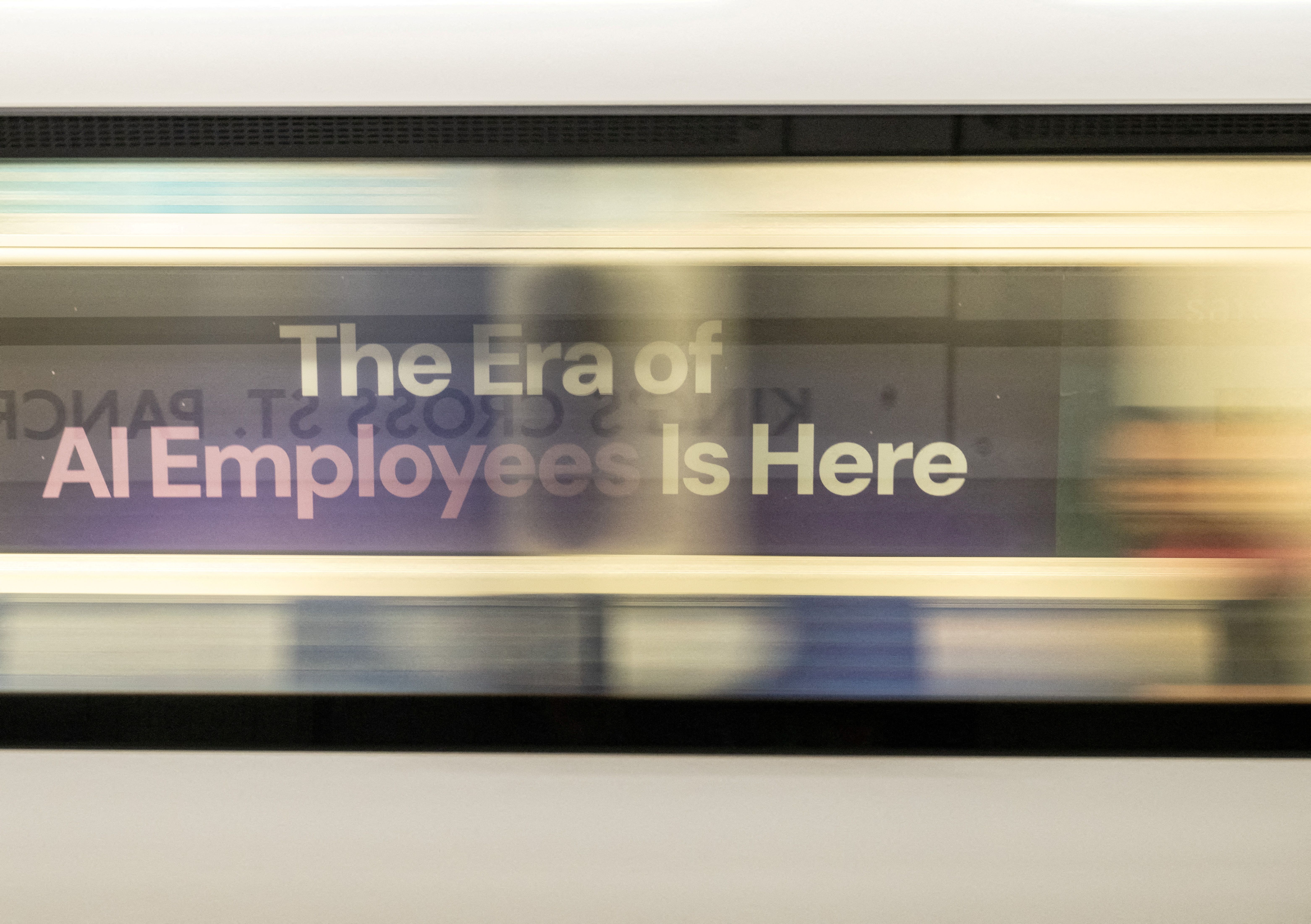 A London underground train passes a billboard for an Artificial Intelligence company advertising AI employees in London, Britain.