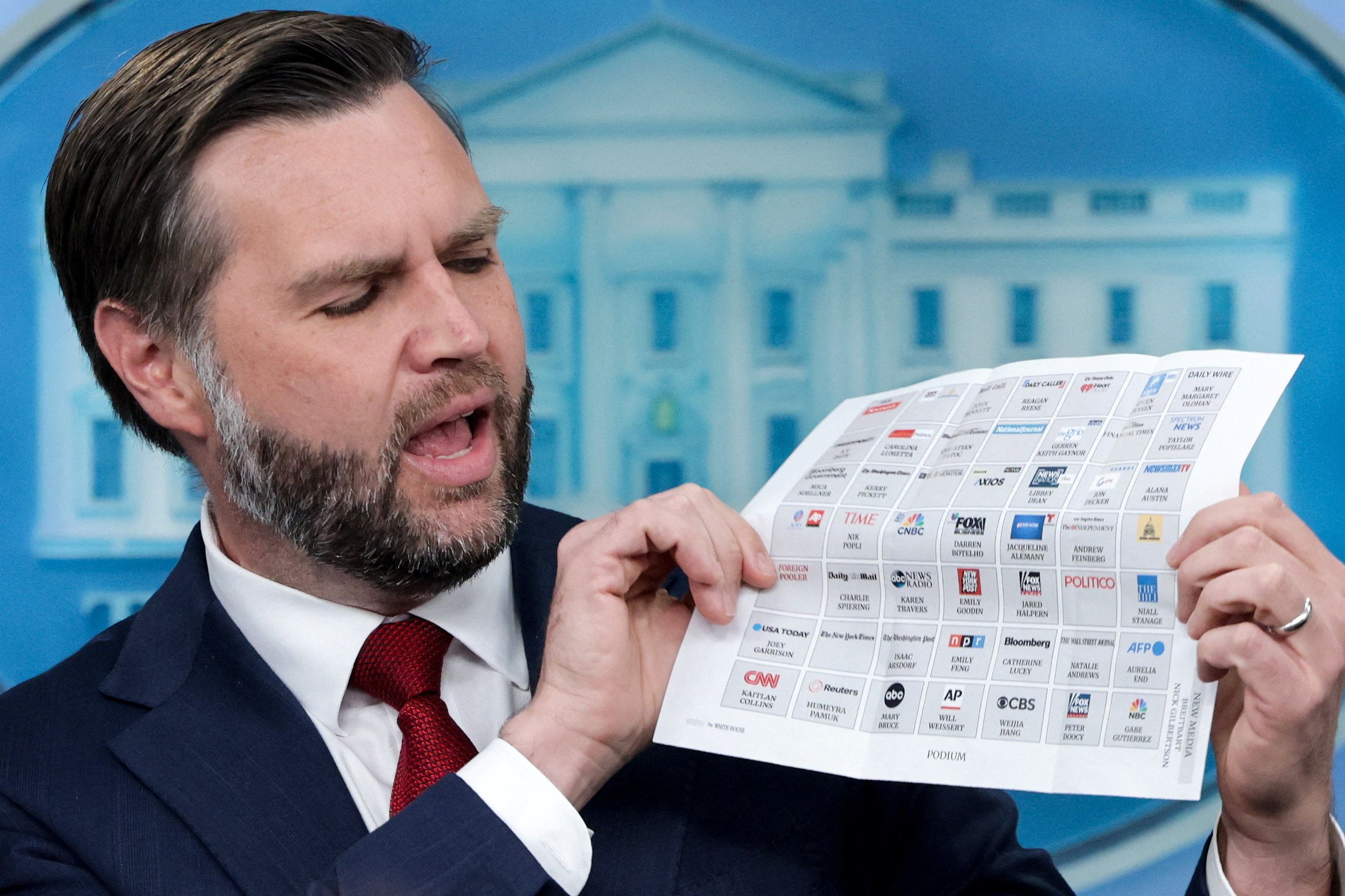 Vice President JD Vance checks a seating chart as he takes questions from reporters. 