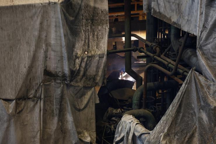 An employee works at a thermal power plant damaged during Russian missile strikes in Ukraine.