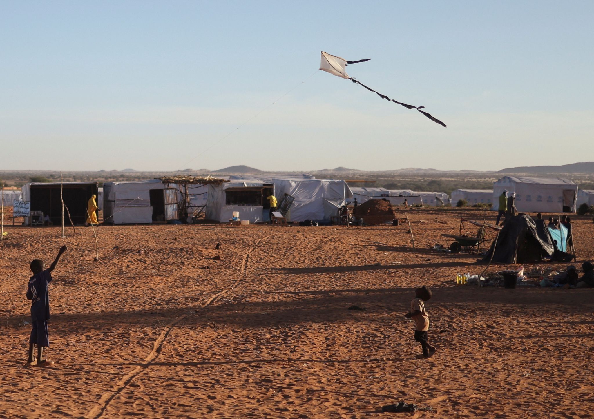 A Sudanese refugee boy from Darfur flies a handmade kite inside the Touloum refugee camp. 