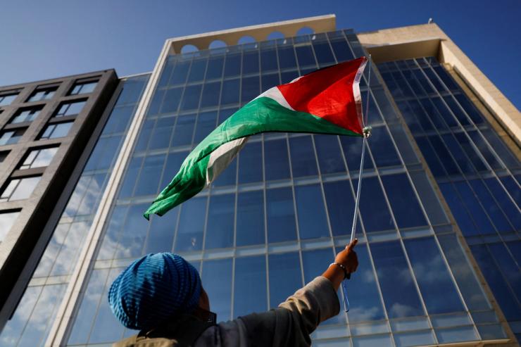 A protester waves a Palestinian flag outside AIPAC offices in Washington.