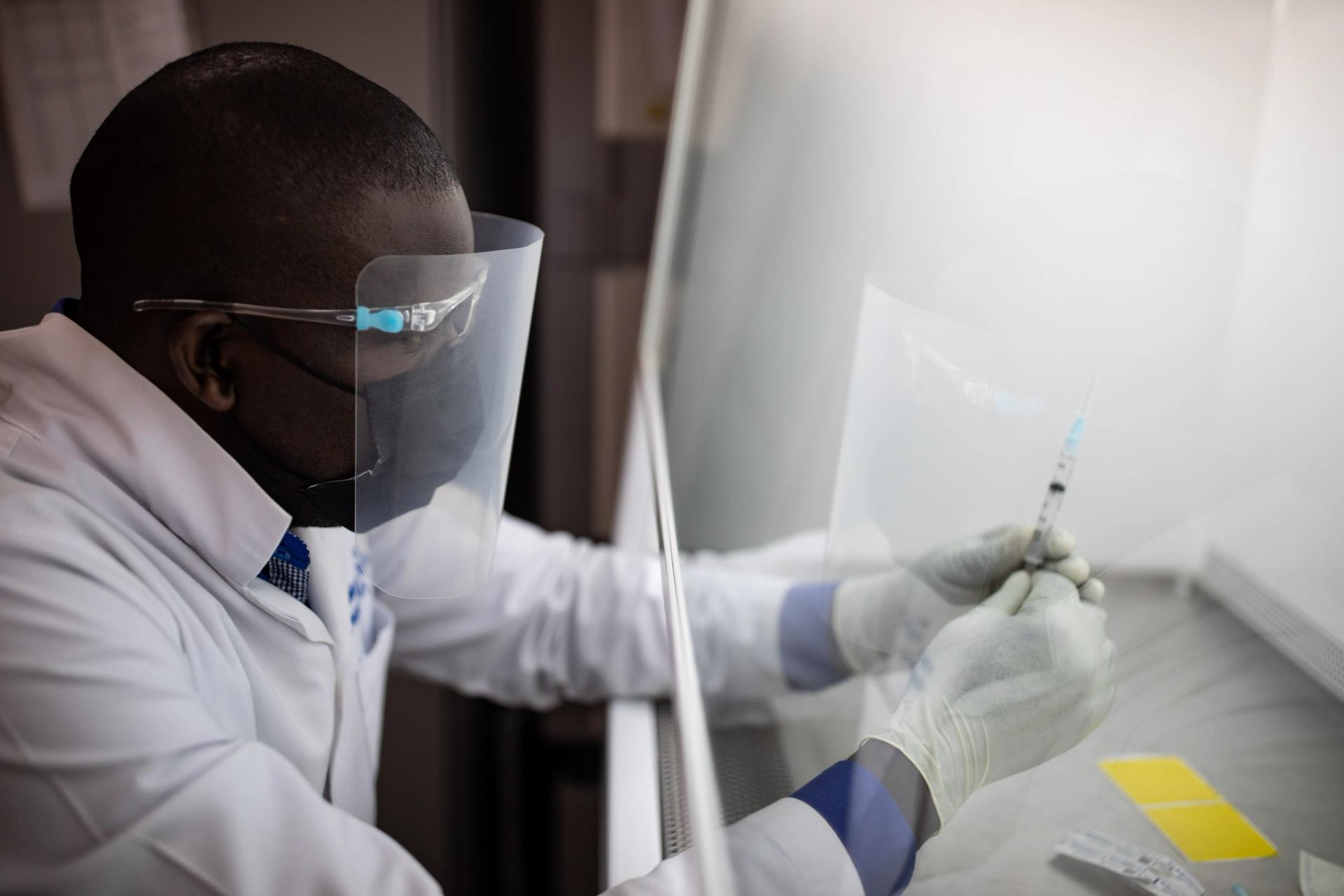 A vaccine pharmacist preparers blind samples as part of an HIV vaccine trial on March 16, 2022 in Masaka, Uganda