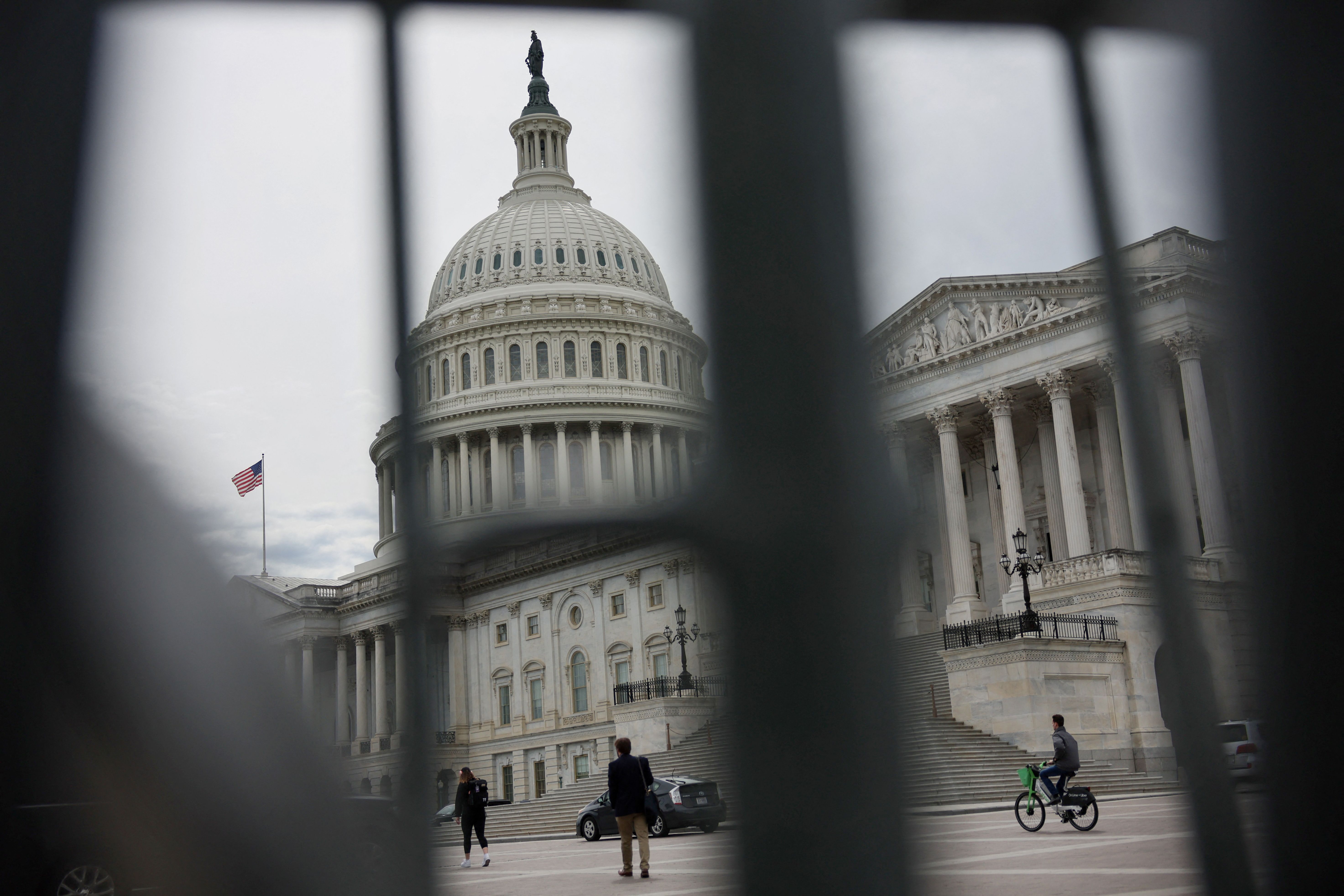 The U.S. Capitol building viewed through the bars of standard barricades in Washington, U.S., April 4, 2025.