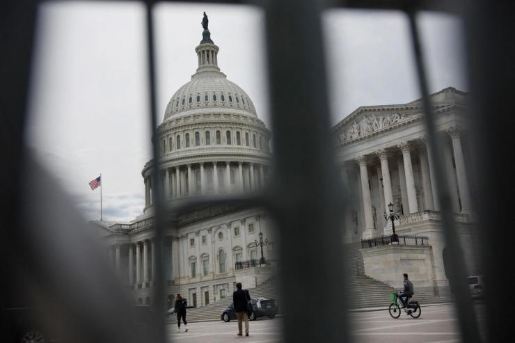 The U.S. Capitol building viewed through the bars of standard barricades in Washington, U.S., April 4, 2025.