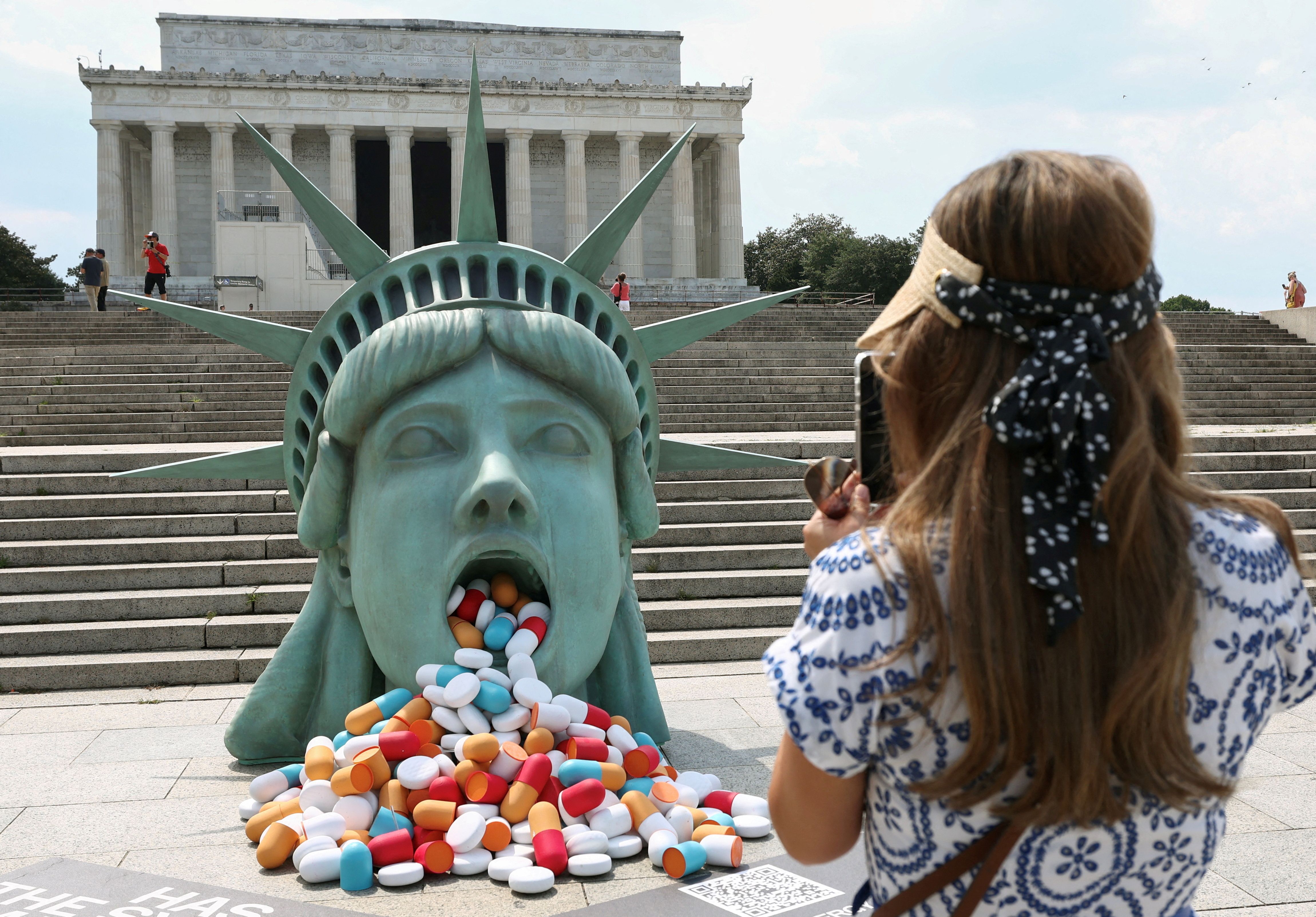 Pills spill out of the mouth a Lady Liberty installation at the Lincoln Memorial