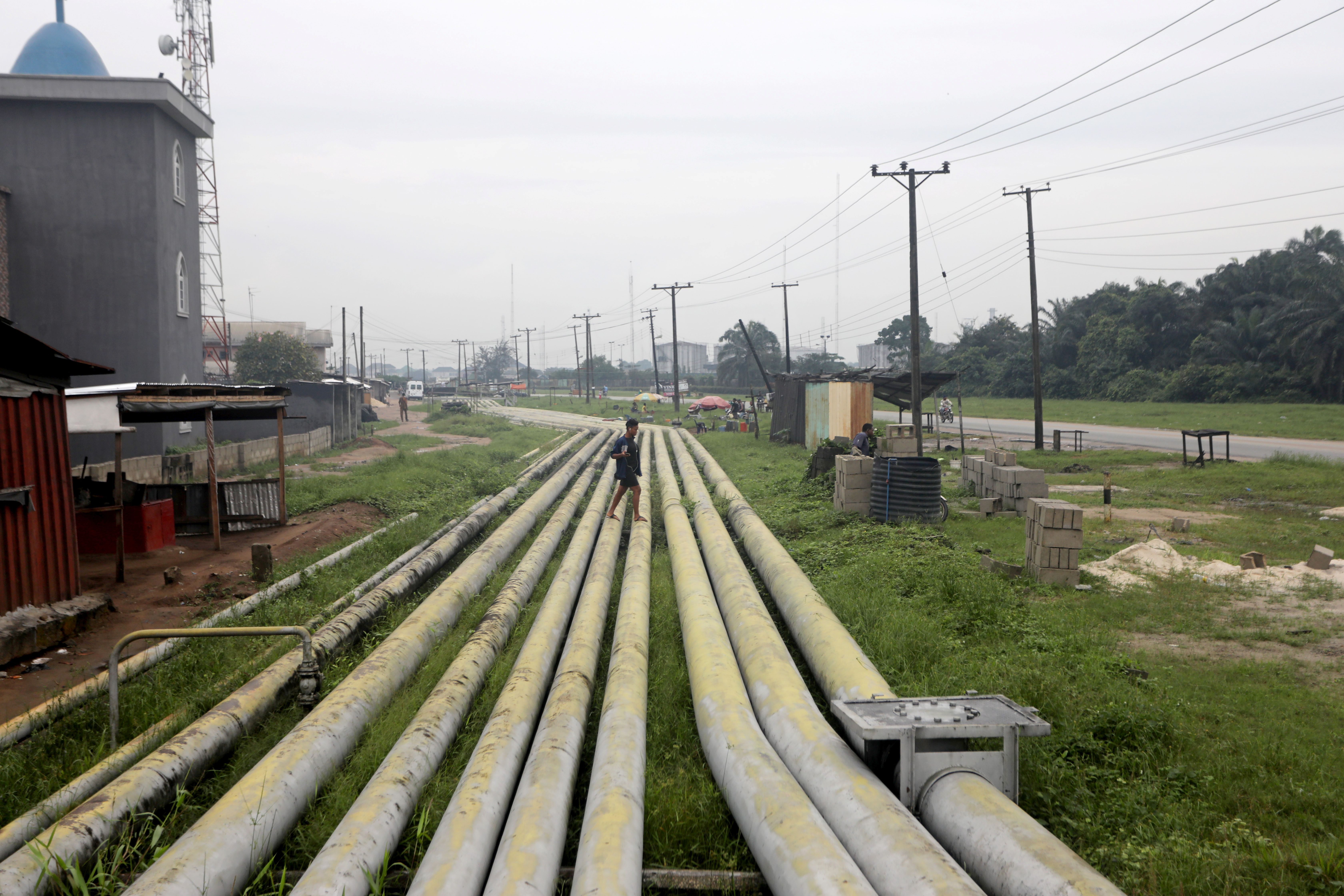 A woman walks over pipelines in Rivers state, Nigeria. 
