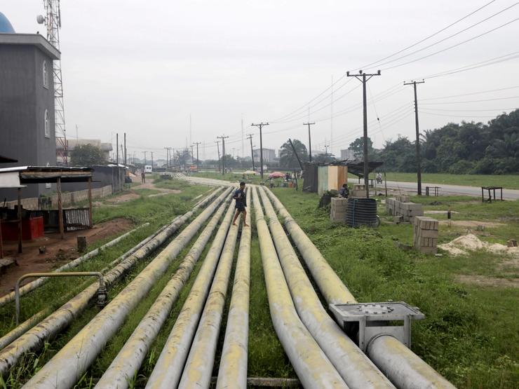 A woman walks over pipelines crisscrossing Ogoniland in Rivers State, Nigeria.
