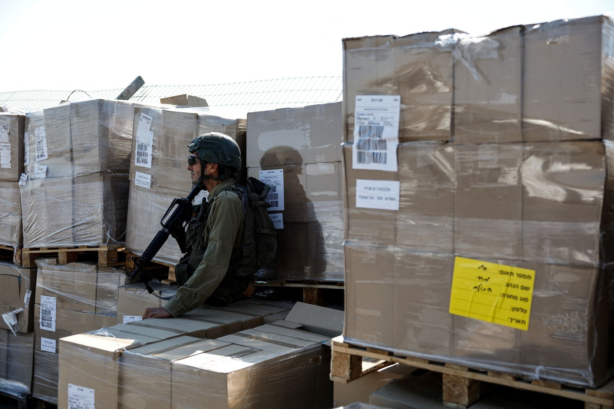 IDF soldier sits atop bozes of aid.