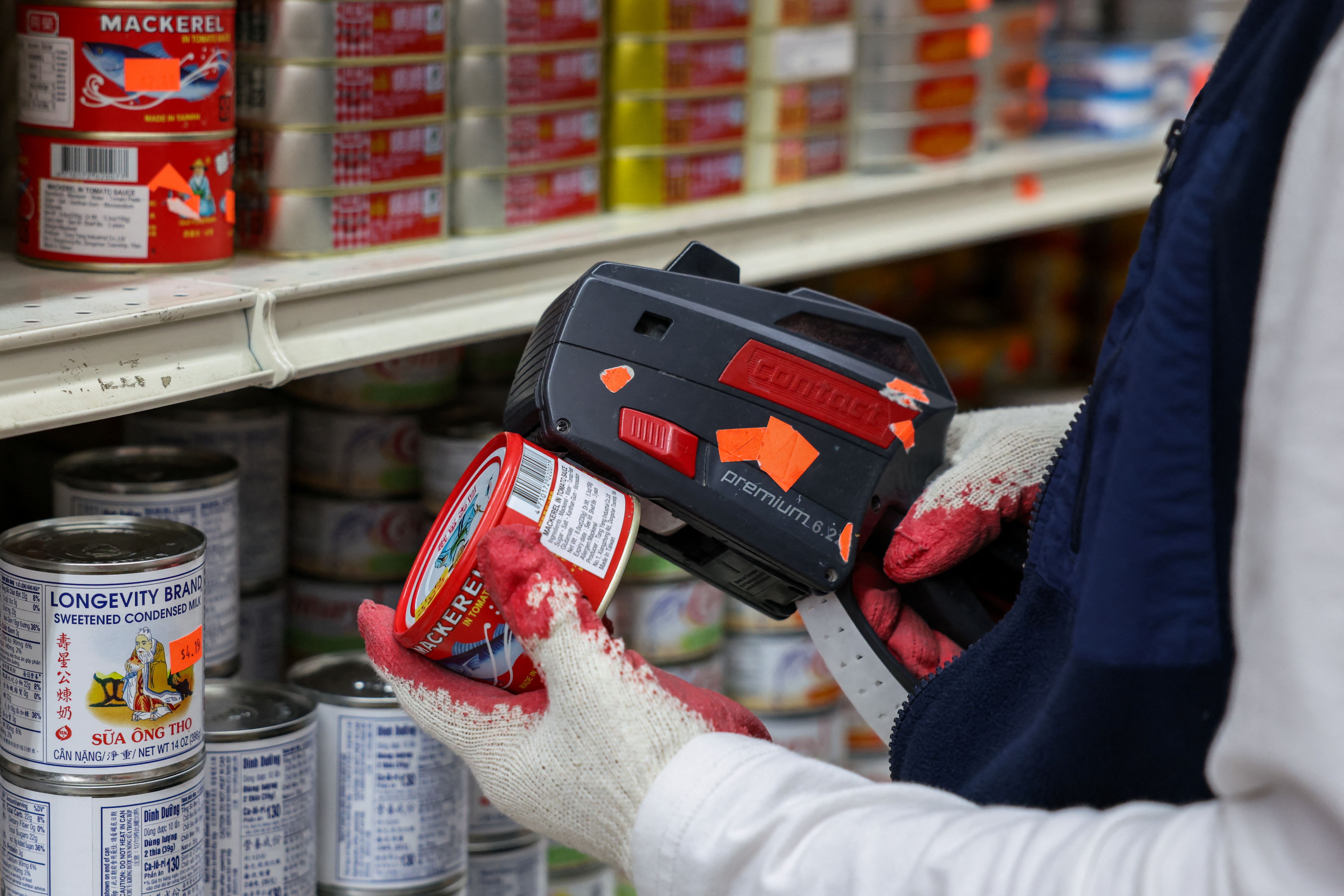 A Sun Vin Grocery employee adds price tags and stocks shelves in Chinatown in New York City US.