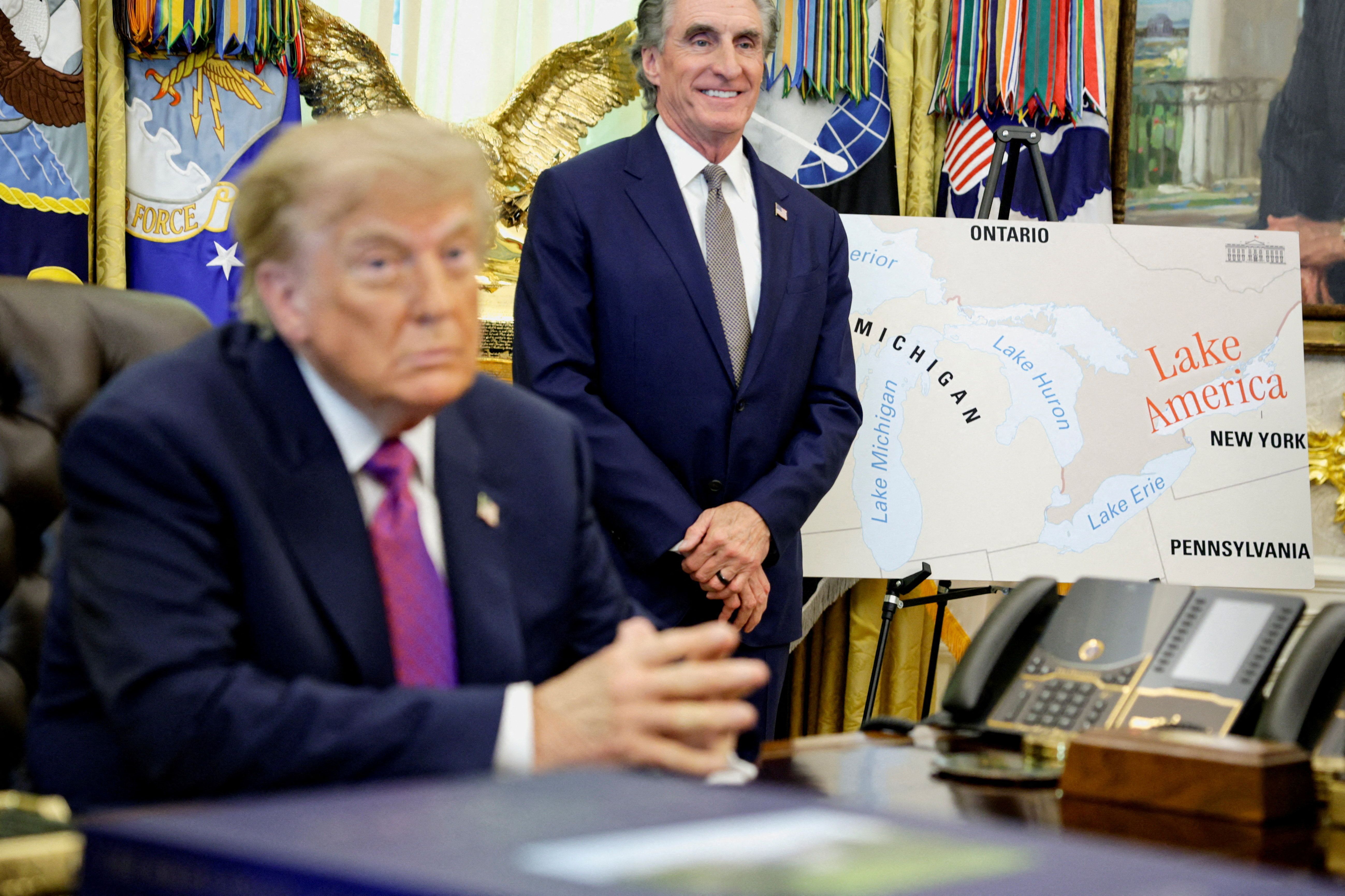 Donald Trump sits next to a map with “Lake America” written on it 