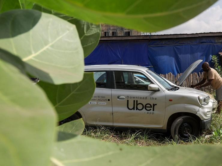 A Nigerian ride-hailing driver working with Uber fixes his car
