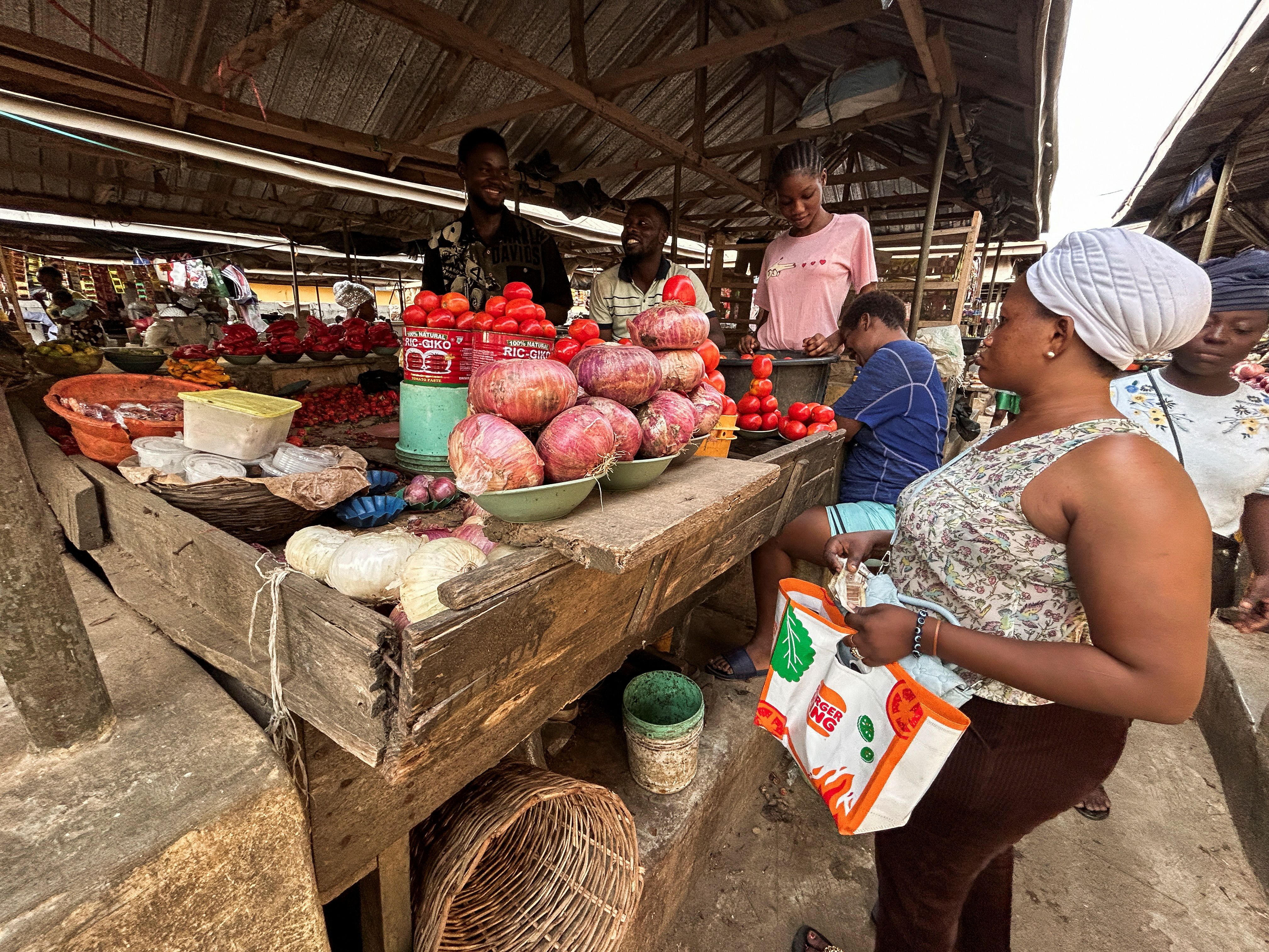 Farouk Dalhatu, a tomatoes seller attends to buyer in a community market of Agodo in Lagos, Nigeria March 6, 2024. REUTERS/Seun Sanni