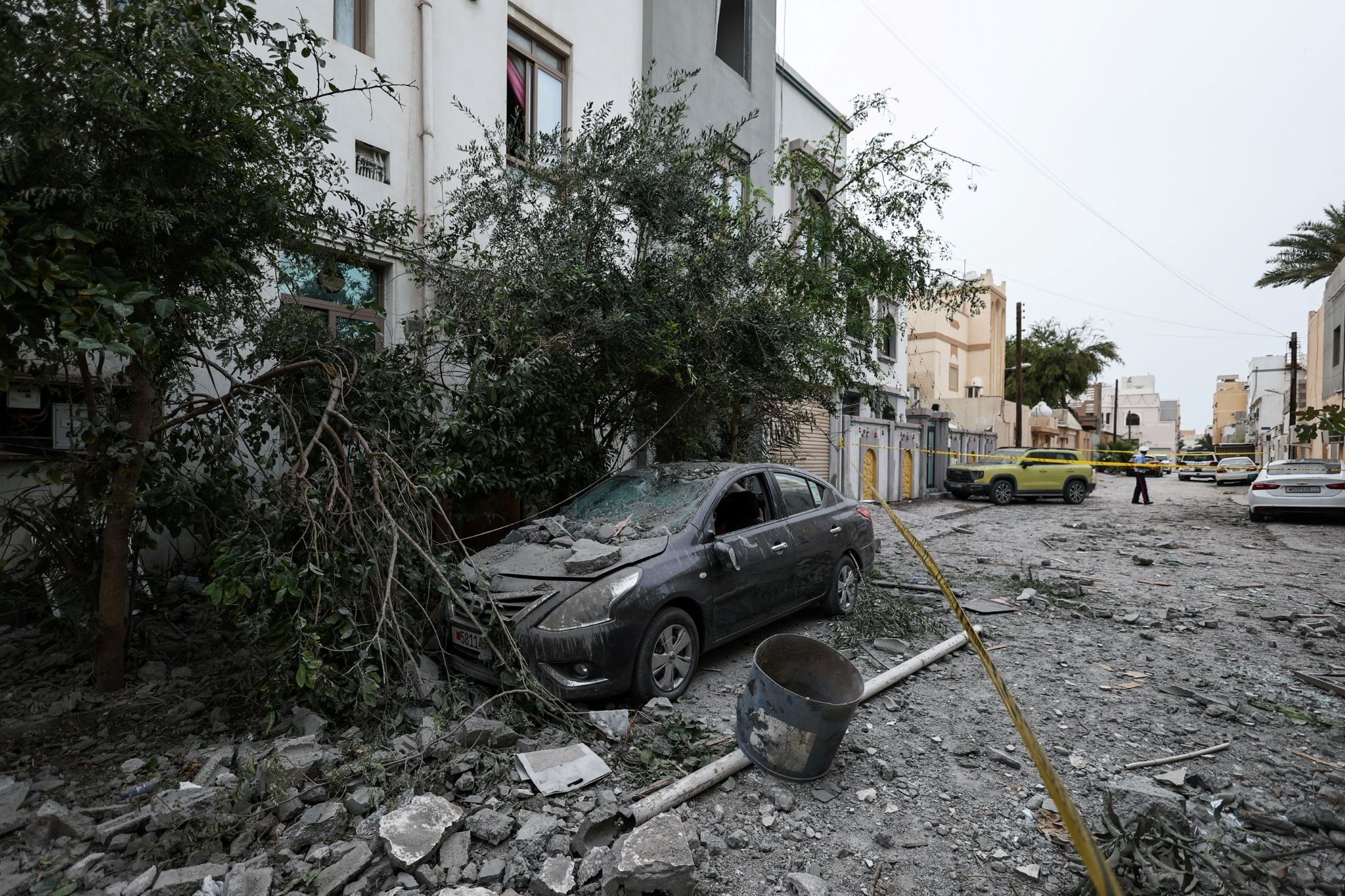 A wrecked car and debris in Sitra, Bahrain