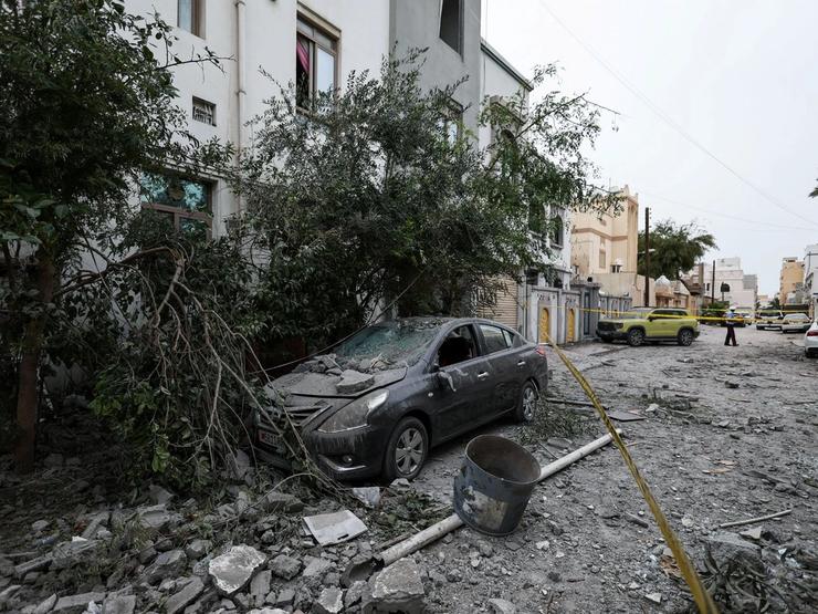 A wrecked car and debris in Sitra, Bahrain