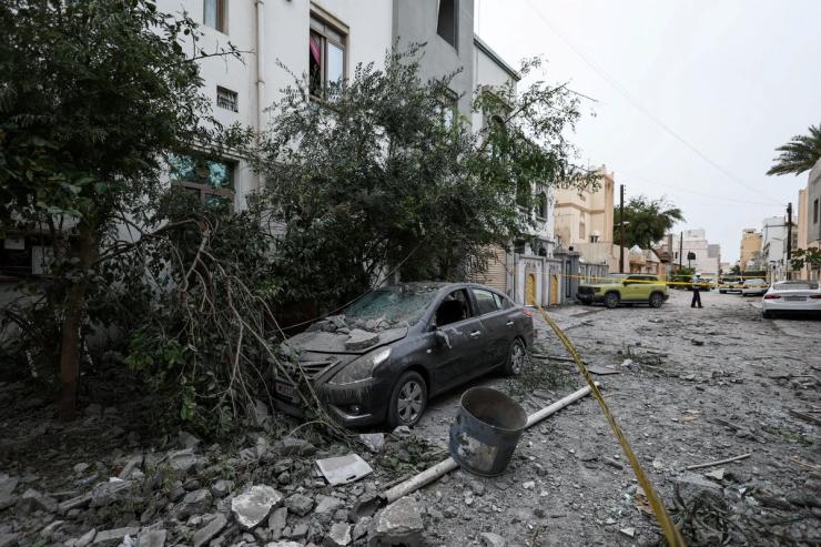 A wrecked car and debris in Sitra, Bahrain
