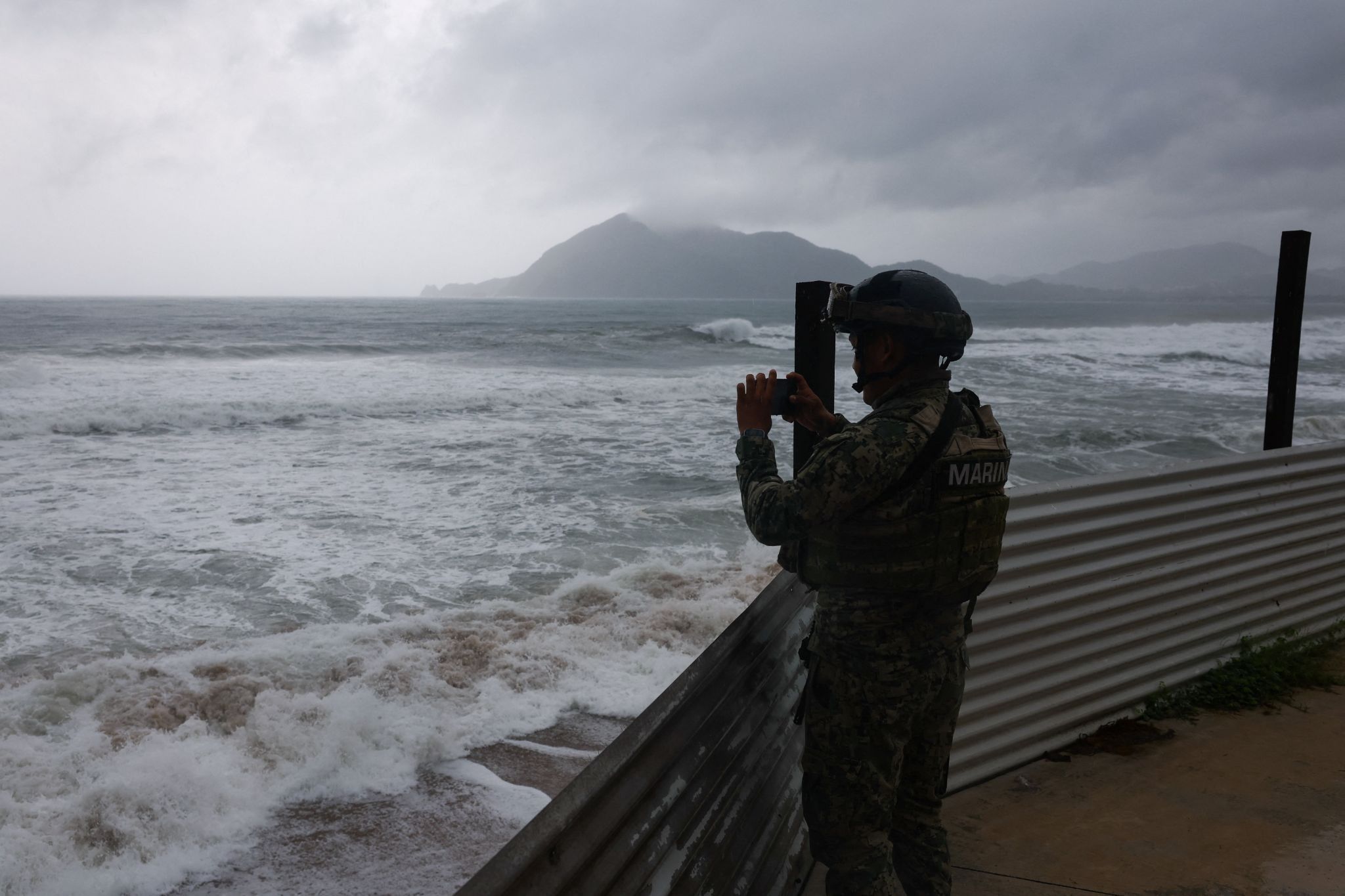 A member of the Navy films while waves hit the shore in Manzanillo, Mexico.
