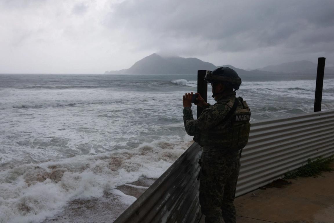 A member of the Navy films while waves hit the shore in Manzanillo, Mexico.