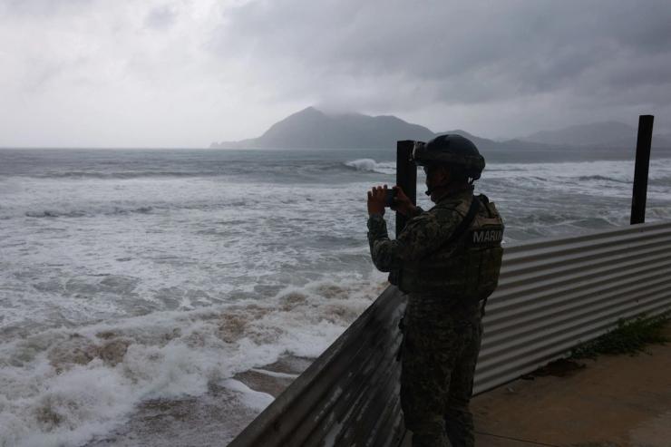 A member of the Navy films while waves hit the shore in Manzanillo, Mexico.