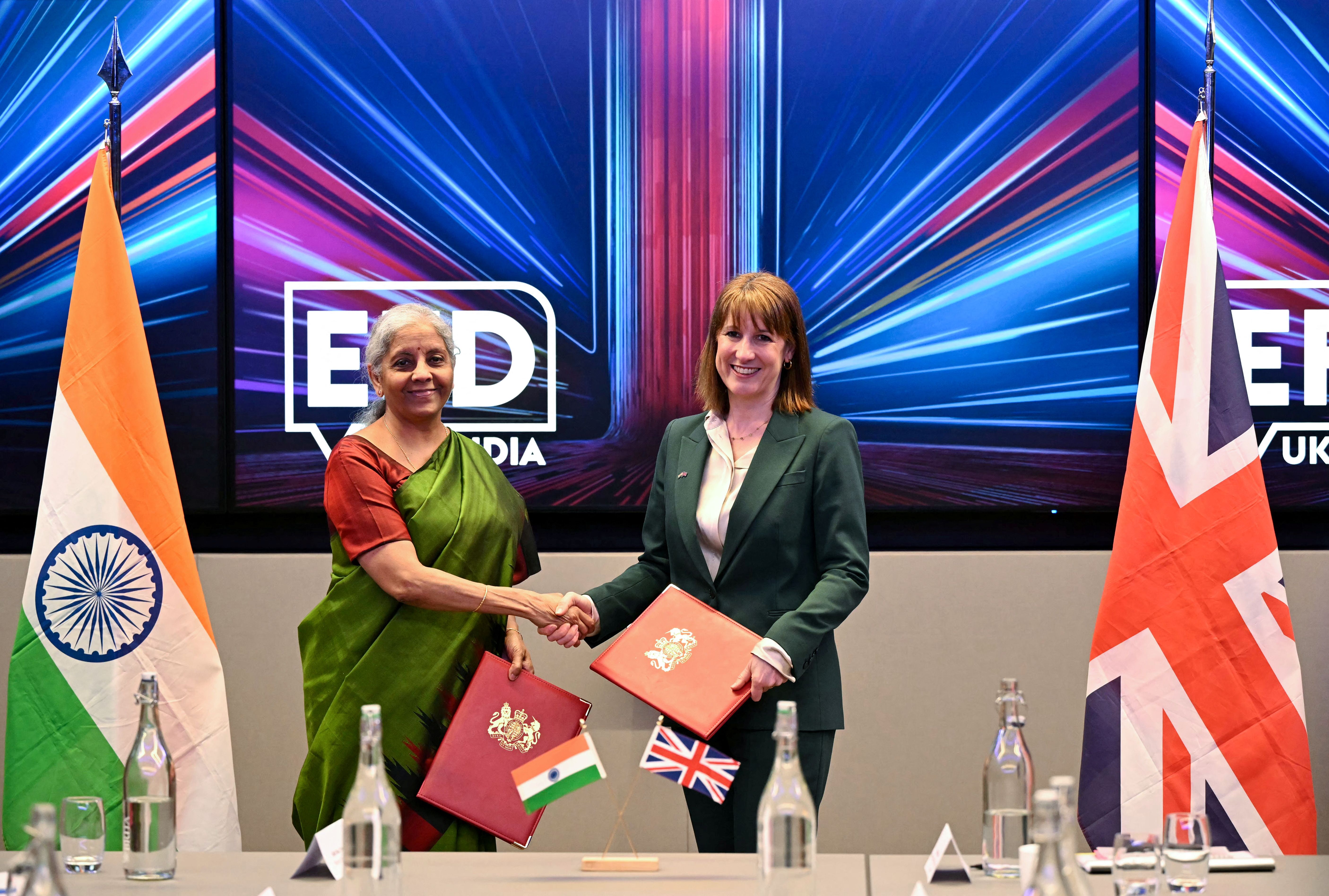 Britain’s Chancellor of the Exchequer Rachel Reeves (R) shakes hands with her Indian counterpart, Finance Minister Nirmala Sitharaman.