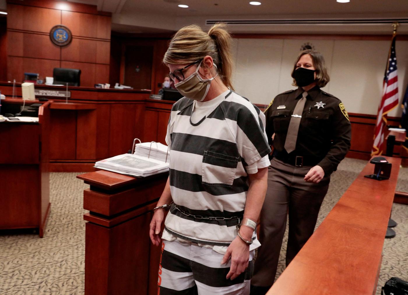 Jennifer Crumbley, the parent of accused Oxford High School gunman Ethan Crumbley, is escorted into the courtroom by an Oakland County Sheriff during a court procedural hearing in Rochester Hills, Michigan, U.S., February 24, 2022. REUTERS/Rebecca Cook/File Photo