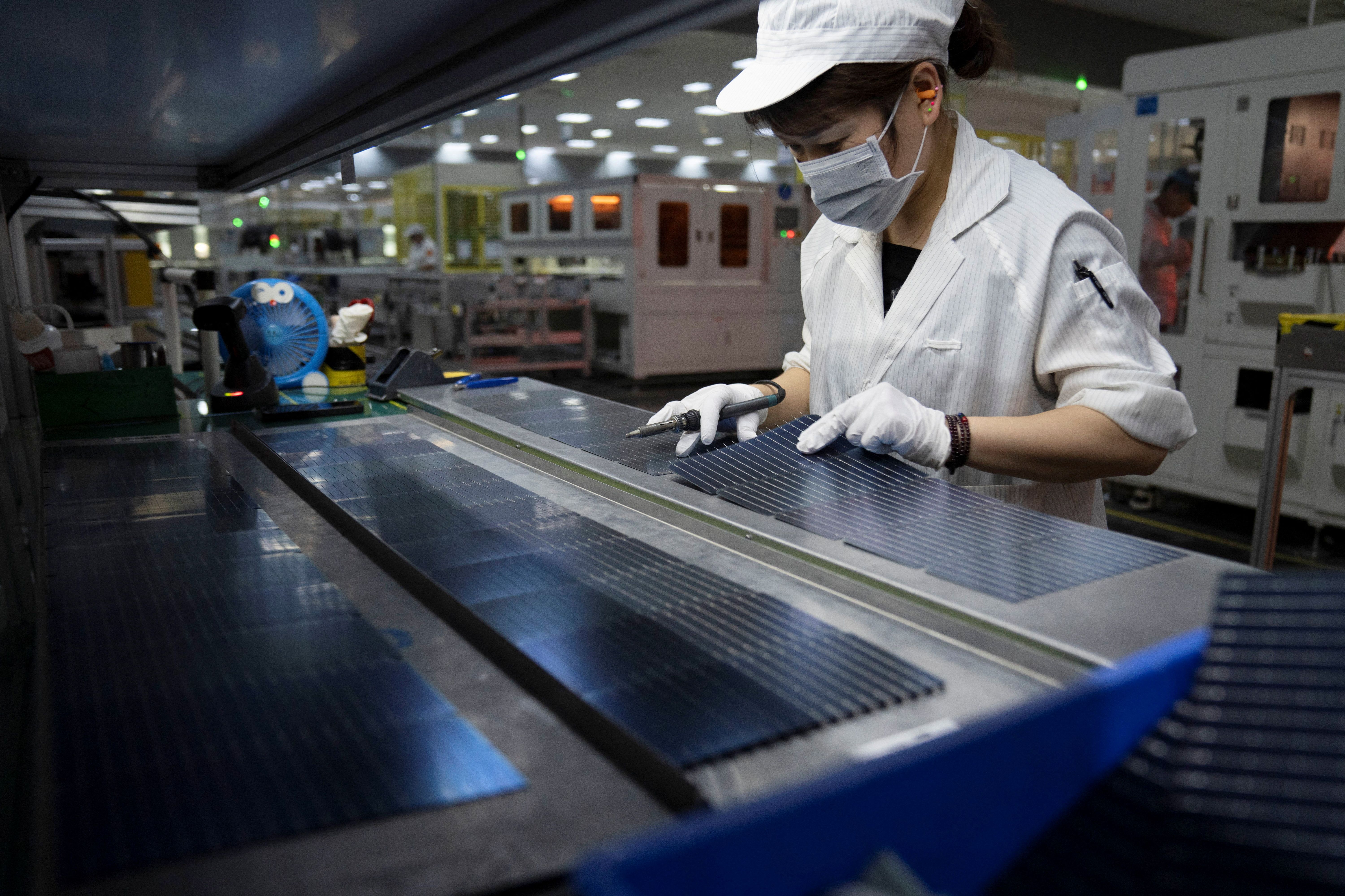An employee works on the production line for solar panels.