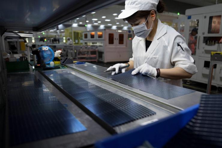 An employee works on the production line for solar panels.