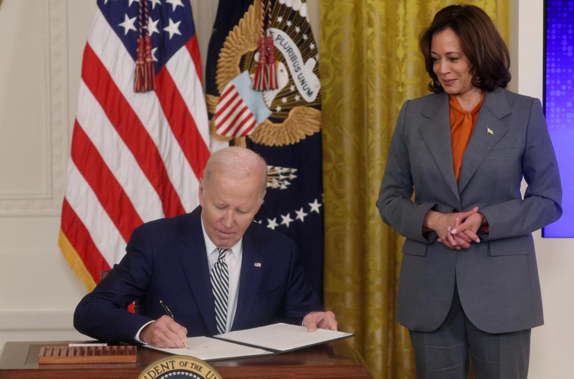 U.S. President Joe Biden signs an Executive Order about Artificial Intelligence as Vice President Kamala Harris looks on, in the East Room at the White House in Washington, U.S., October 30, 2023.