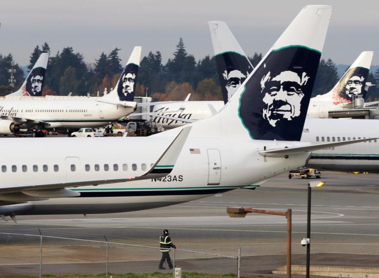 A ground crew member walks near Alaska Airlines planes parked at Seattle-Tacoma International Airport in SeaTac.